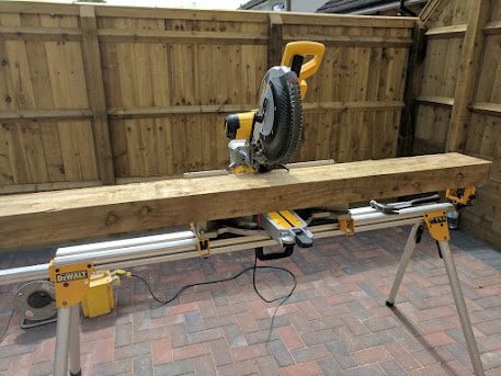 DeWalt mitre saw on its stand, cutting a sleeper to length