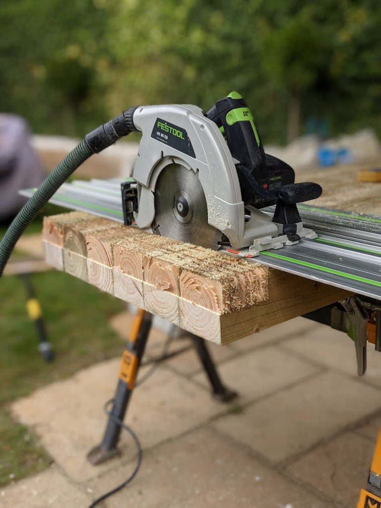 Festool HK 85 circular saw on a guide rail, cutting through stacked sleepers