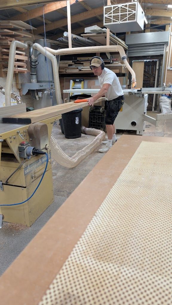 Feeding timber through a machine in the workshop