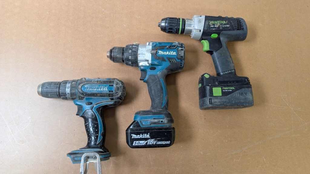 Three cordless drills side by side on a workbench, comparing cordless drills for beginners