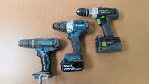 Three cordless drills side by side on a workbench, comparing cordless drills for beginners