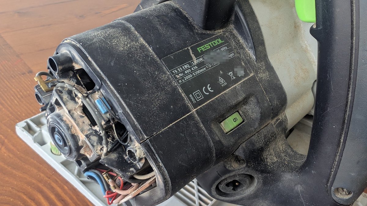 The opened motor housing of a Festool plunge saw, with the carbon brushes and wiring visible