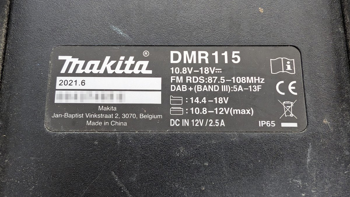 The rating plate on a Makita DMR115 site radio, showing its IP65 rating alongside the voltage and radio band details